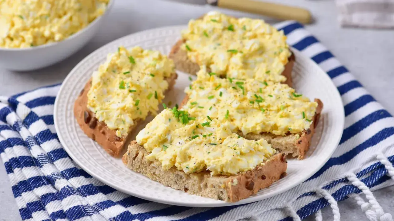 Pyszna pasta z jajek na chlebie, posypana szczypiorkiem i pieprzem. Idealna na szybkie śniadanie lub przekąskę.