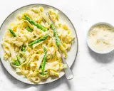 Pyszny makaron ze szparagami w kremowym sosie, posypany parmezanem. Idealny na lekki obiad.