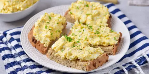 Pyszna pasta z jajek na chlebie, posypana szczypiorkiem i pieprzem. Idealna na szybkie śniadanie lub przekąskę.