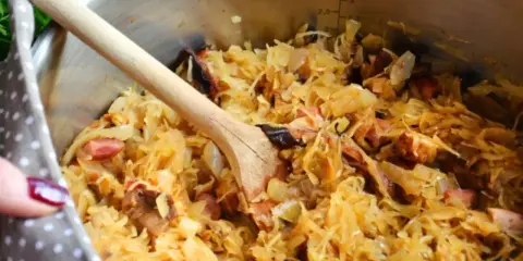 Gotujesz bigos? W garnku widać kapustę kiszoną z różnymi rodzajami mięsa, jak wieprzowina i kiełbasa. Idealne jakie mięso do bigosu!