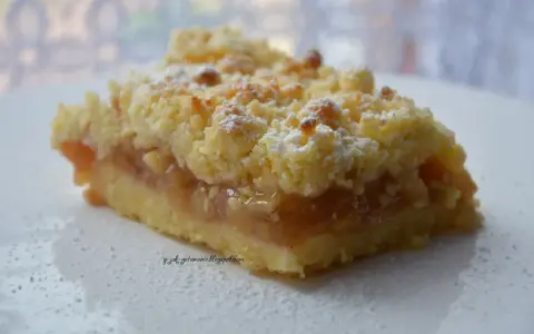 Pyszna tarta z jabłkami, posypana cukrem pudrem, kusi chrupiącą kruszonką i aromatycznym nadzieniem.