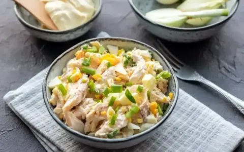 Pyszna sałatka z wędzonym kurczakiem, jajkiem i szczypiorkiem, polana majonezem. Idealna na szybki lunch.