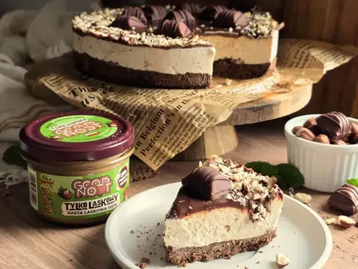 Pyszne ciasto z mascarpone, czekoladą i orzechami laskowymi. Obok słoiczek pasty z orzechów laskowych.