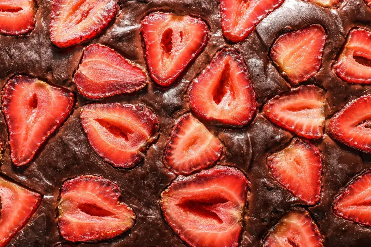 Pyszny brownie z truskawkami, z kawałkami owoc&oacute;w zatopionymi w czekoladowym cieście.
