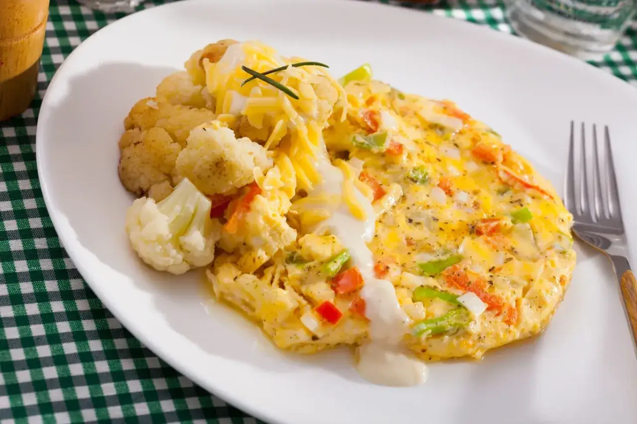 Pyszny omlet z warzywami i serem, obok kalafior. Świetny pomysł, co zrobić z białek na śniadanie!