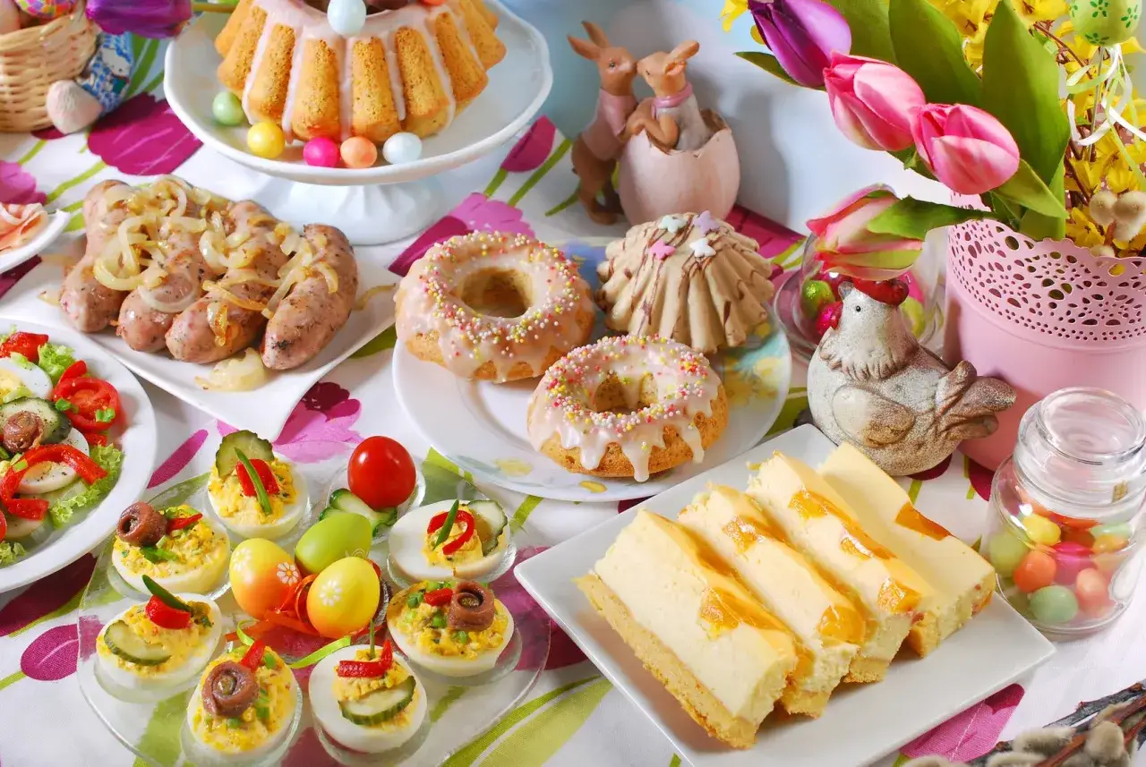 Wielkanocny stół ugina się od pyszności: babka, kiełbaski, jajka faszerowane, sernik i pączki. Dania wielkanocne na gorąco i słodkości.